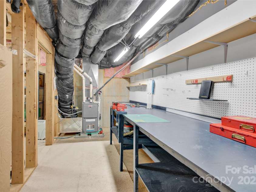 7028 Kitty Hawk Lane, Fort Mill, SC 29707.  MLS# CAR4285011, YatesRealty ID 30903. Workshop complete with bench, pegboard, and its heated/cooled.