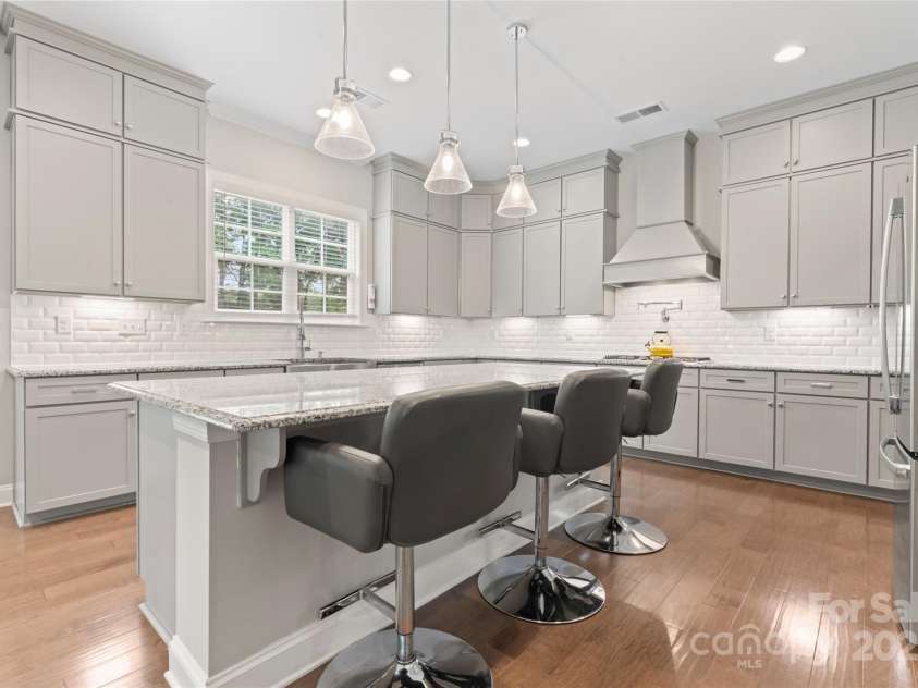 4008 Pinot Way, Fort Mill, SC 29707.  MLS# CAR4268803, YatesRealty ID 30944. The large, unobstructed island, pendant lights, upgraded cabinetry, and designer tile shows why this kitchen would be the heart of the home.