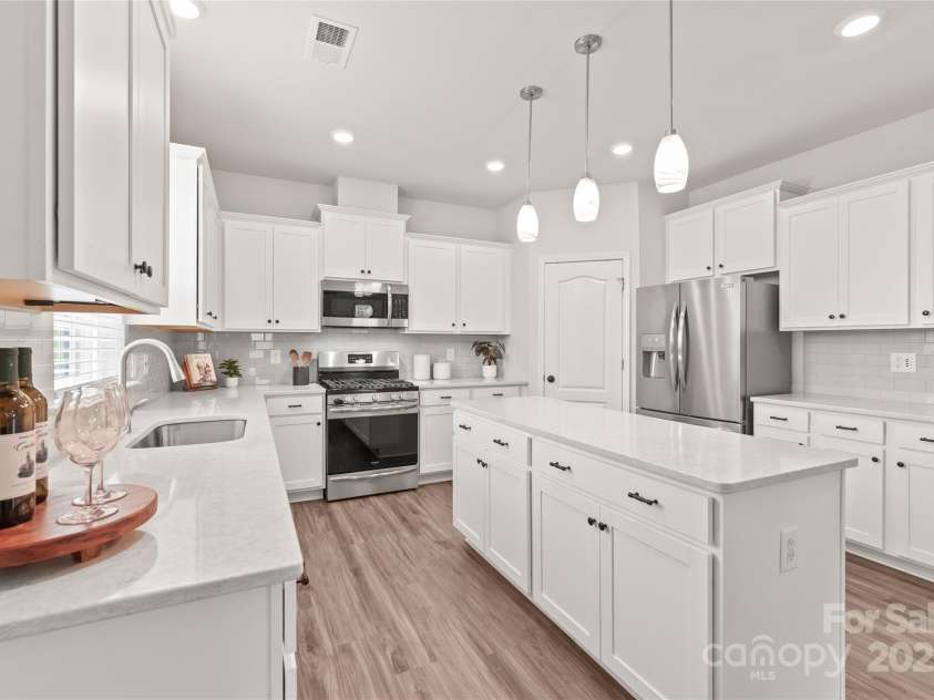 16726 Cozy Cove Road, Charlotte, NC 28278.  MLS# CAR4288880, YatesRealty ID 30958. Sleek quartz surfaces, a functional island, and eye-catching pendants make this kitchen the heart of the home.
