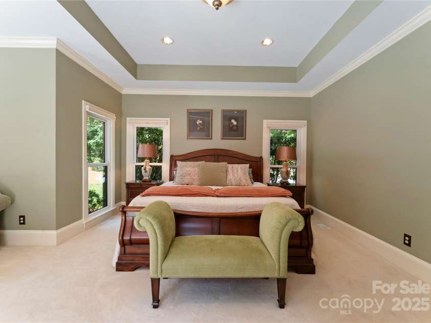 18600 River Falls Drive, Davidson, NC 28036.  MLS# CAR4231533, YatesRealty ID 30985. Oversized Primary Bedroom on Main Floor with Trey Ceiling, recessed lighting and a newer sliding door leading to the patio.