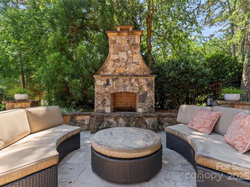 18600 River Falls Drive, Davidson, NC 28036.  MLS# CAR4231533, YatesRealty ID 30985. Wood Burning outdoor stone fireplace with stone hearth and seating area.