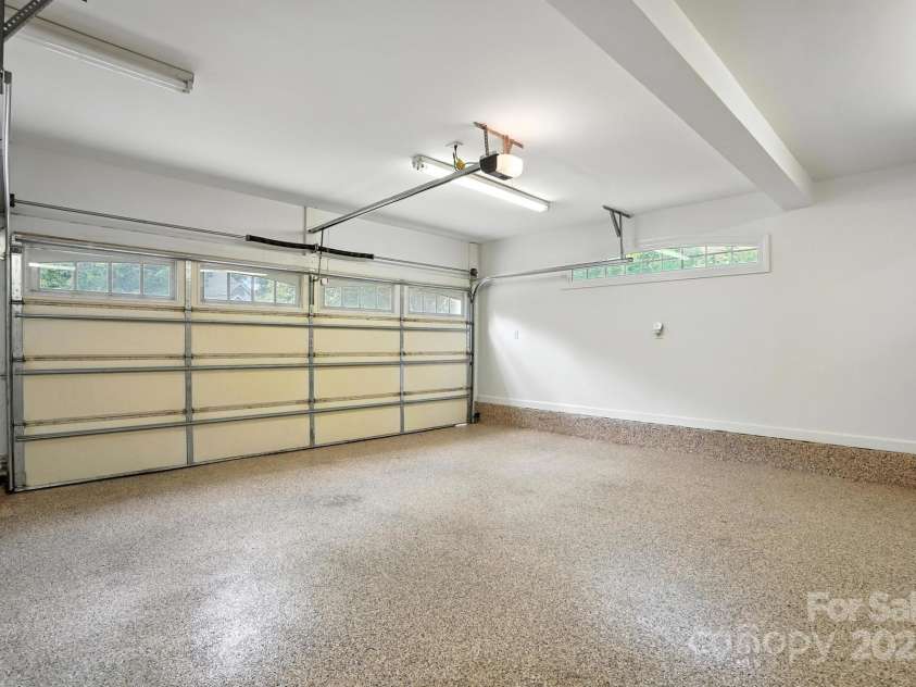11108 Broken Brook Way, Tega Cay, SC 29708.  MLS# CAR4281529, YatesRealty ID 31004. This garage offers a durable and functional space, ideal for a variety of uses, from vehicle storage to workshop activities. A key feature of this garage is its epoxy floor coating, which provides a seamless and resi