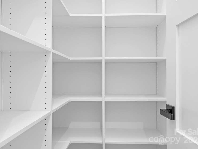 106 Arbor Drive, Waxhaw, NC 28173.  MLS# CAR4264071, YatesRealty ID 31005. This custom pantry offers plenty of storage with sleek, built-in shelving and modern design, making it easy to stay organized and keep everything you need within reach.