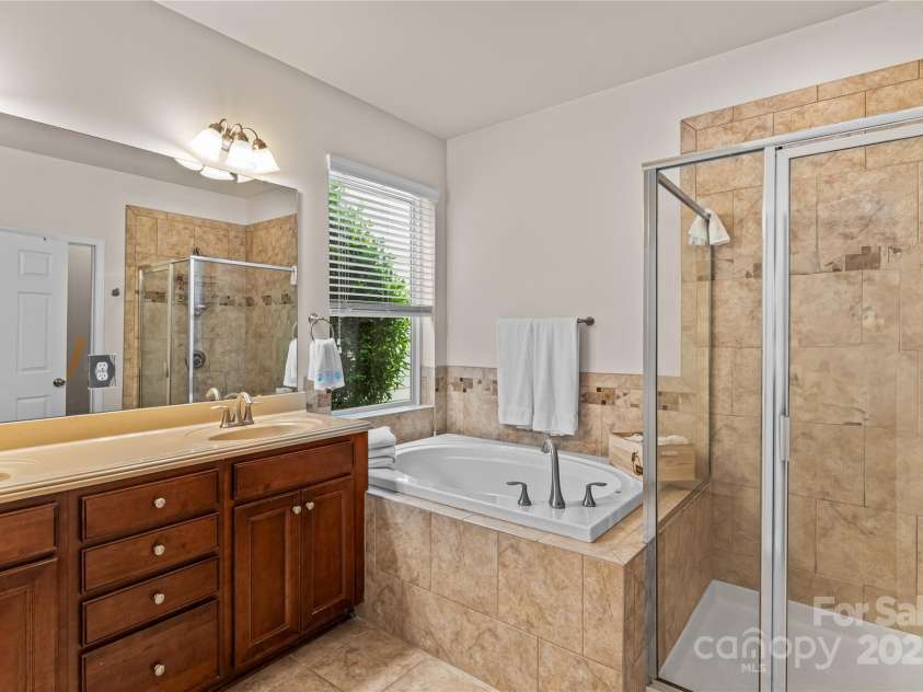 17311 Lake Path Drive, Cornelius, NC 28031.  MLS# CAR4284922, YatesRealty ID 31030. Primary bathroom with dual vanities, spa-size tub, large shower and walk-in closet.