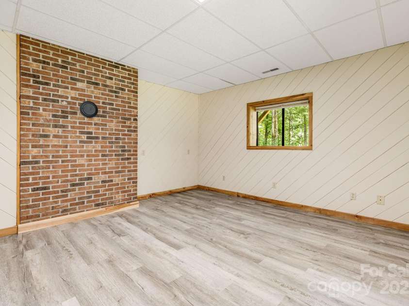 24 Penne Way, Flat Rock, NC 28731.  MLS# CAR4269112, YatesRealty ID 31045. The bonus room can be used for a variety of purposes and features a brick wall with a place for a wood stove