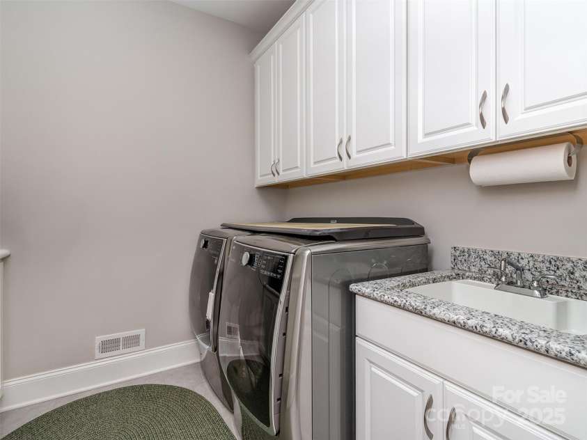 1011 Golden Bell Drive, Marvin, NC 28173.  MLS# CAR4270289, YatesRealty ID 31056. Main Floor Laundry Room with Cabinets and Sink.