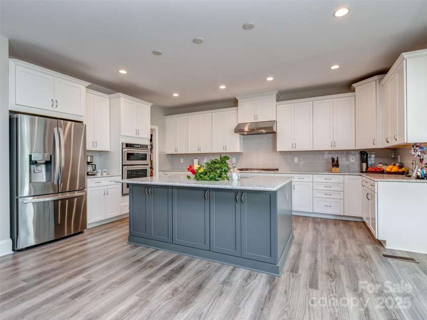 1011 Golden Bell Drive, Marvin, NC 28173.  MLS# CAR4270289, YatesRealty ID 31056. Oversized gourmet kitchen with huge island, recessed lighting, pendant pre-wire, tons of counter space, gas cooktop, vent hood, wall oven with microwave, and all open to great room, sun room, & large walk-in pantry.