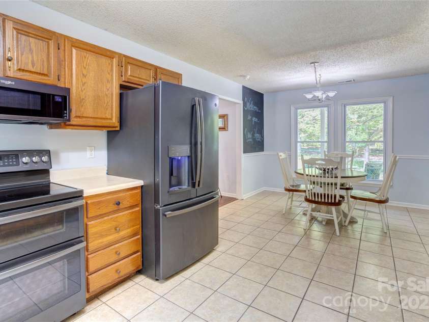 8913 Gosnell Drive, Charlotte, NC 28227.  MLS# CAR4289170, YatesRealty ID 31091. Kitchen off the living room with a refrigerator stays for the buyer. 