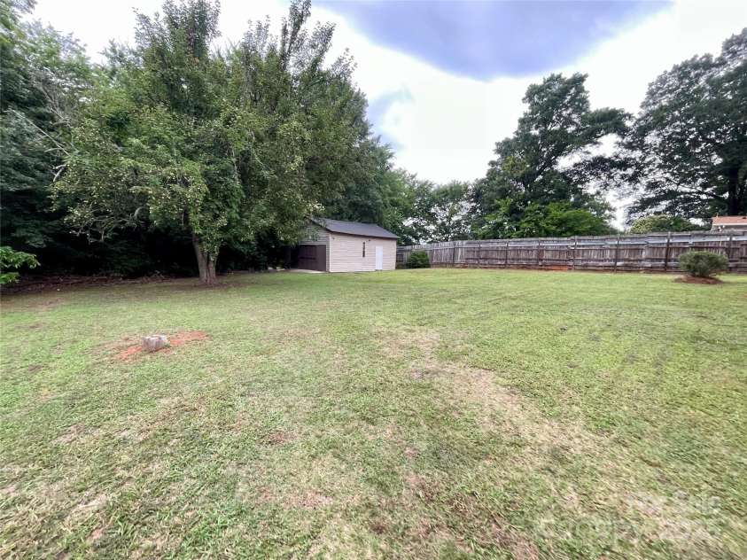 400 Lucy Avenue, Concord, NC 28027.  MLS# CAR4280783, YatesRealty ID 31101. Backyard w/outdoor garage/shed & pear tree