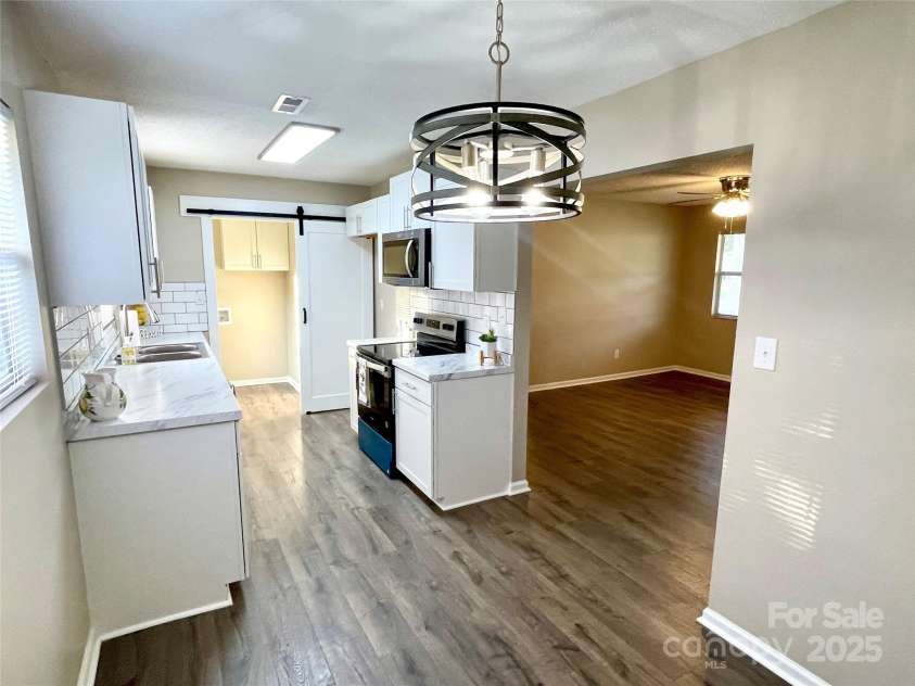 400 Lucy Avenue, Concord, NC 28027.  MLS# CAR4280783, YatesRealty ID 31101. Kitchen w/barn door open into laundry