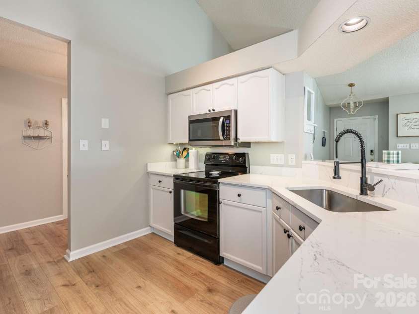 3930 Huntmeadow Drive, Charlotte, NC 28269.  MLS# CAR4387063, YatesRealty ID 31125. Quartz counters and white cabinets provide a sleek look to the kitchen