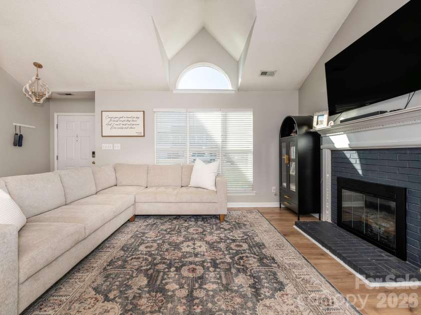3930 Huntmeadow Drive, Charlotte, NC 28269.  MLS# CAR4387063, YatesRealty ID 31125. Welcoming living room with a fireplace and a Palladian window for natural light