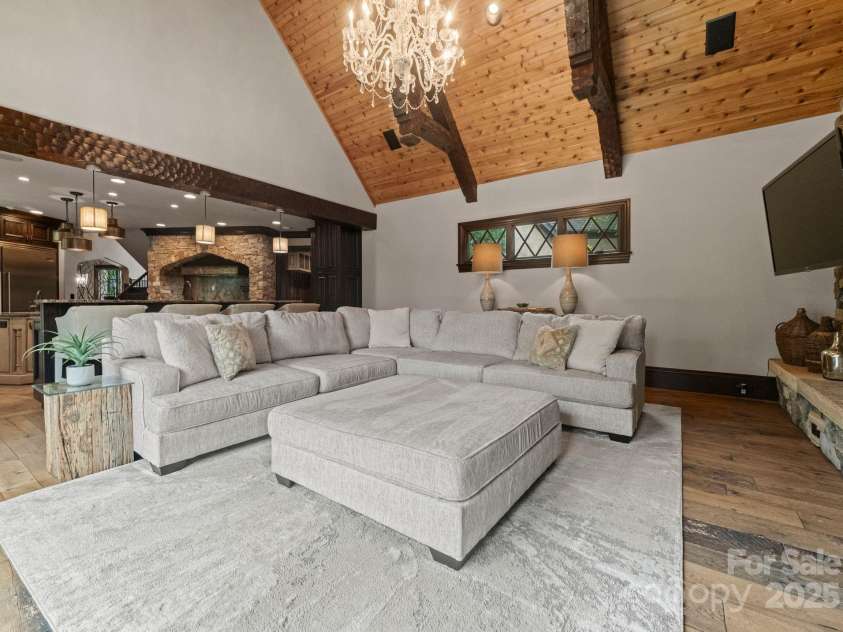 172 Tennessee Circle, Mooresville, NC 28117.  MLS# CAR4252701, YatesRealty ID 3115. Living Room with stone fireplace, dual TVs, and doors to outdoor patio.