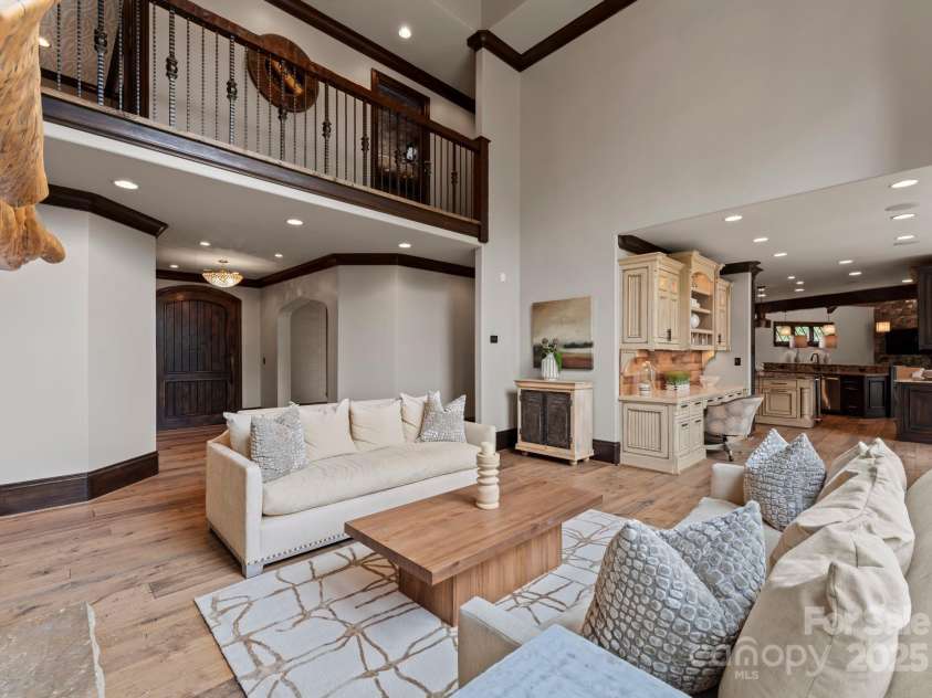 172 Tennessee Circle, Mooresville, NC 28117.  MLS# CAR4252701, YatesRealty ID 3115. Two-story living room with fireplace, chandelier, and custom cabinetry.