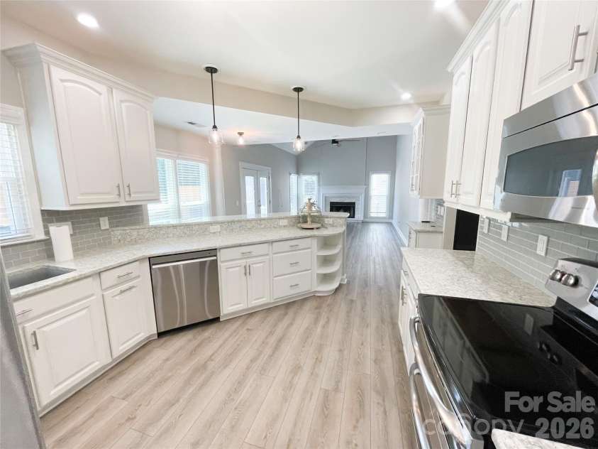 19942 Scanmar Lane, Cornelius, NC 28031.  MLS# CAR4381771, YatesRealty ID 31153. Bright renovated kitchen with quartz counters, recessed lights,  Large Breakfast Bar, Double Oven, Refrigerator Conveys