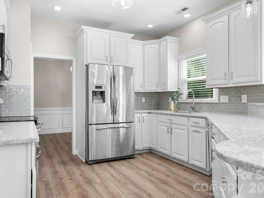 19942 Scanmar Lane, Cornelius, NC 28031.  MLS# CAR4381771, YatesRealty ID 31153. Kitchen with Quartz Counters, Large Breakfast Bar area, Tons of Cabinets, Pantry, Built in Microwave, Refrigerator and Double oven.  Recessed Dimmer Lights, LVP Flooring, and Open to Family Room
