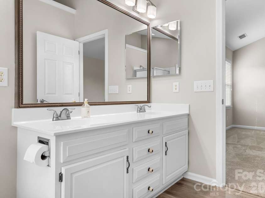19942 Scanmar Lane, Cornelius, NC 28031.  MLS# CAR4381771, YatesRealty ID 31153. Primary Bathroom with Double sinks, upgraded mirror and lights. Soaking Tub with Corner Winows for tons of light!