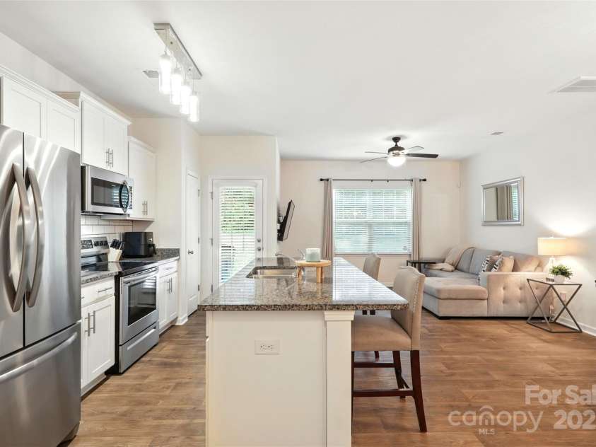 6018 Guildford Hill Lane, Charlotte, NC 28215.  MLS# CAR4287147, YatesRealty ID 31154. Modern design kitchen featuring stainless steel appliances, granite countertops, subway tile backsplash, and a center island with additional seating.