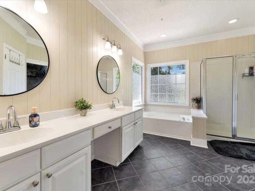 1524 Candlewyck Court, Kannapolis, NC 28081.  MLS# CAR4279653, YatesRealty ID 31163. Primary ensuite bathroom with dual sinks  tiled floors, updated lighting, separate tub and shower, and a water closet.