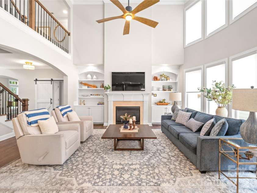 25017 Stonekirk Lane, Fort Mill, SC 29707.  MLS# CAR4383231, YatesRealty ID 31182. With its dramatic architectural details, custom built-ins, and massive windows that bring the outdoors in, this show-stopping two-story great room is the definition of 