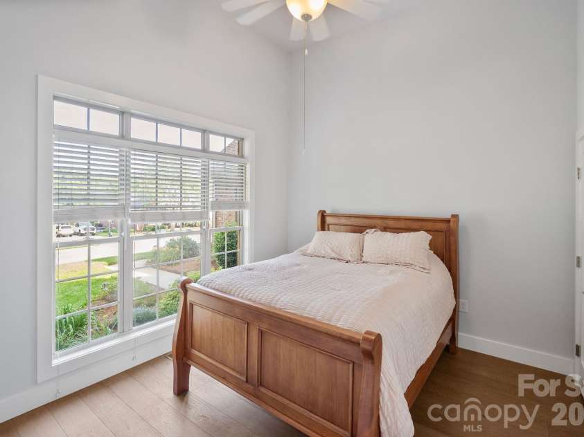 526 Ballymote Court, Matthews, NC 28104.  MLS# CAR4388258, YatesRealty ID 31207. Bright and inviting, this spacious bedroom features vaulted ceilings, large windows, and warm hardwood flooring, creating a comfortable retreat filled with natural light.