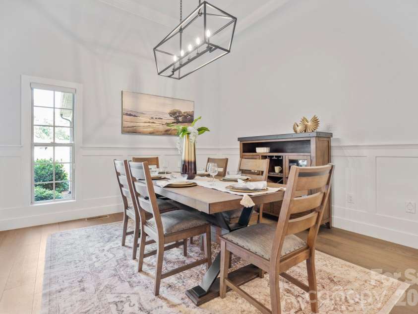 526 Ballymote Court, Matthews, NC 28104.  MLS# CAR4388258, YatesRealty ID 31207. Dining Room – Thoughtfully designed formal dining room featuring wide-plank flooring, elegant crown molding, and a striking modern chandelier. Generous proportions provide ample space for hosting family dinners and holi