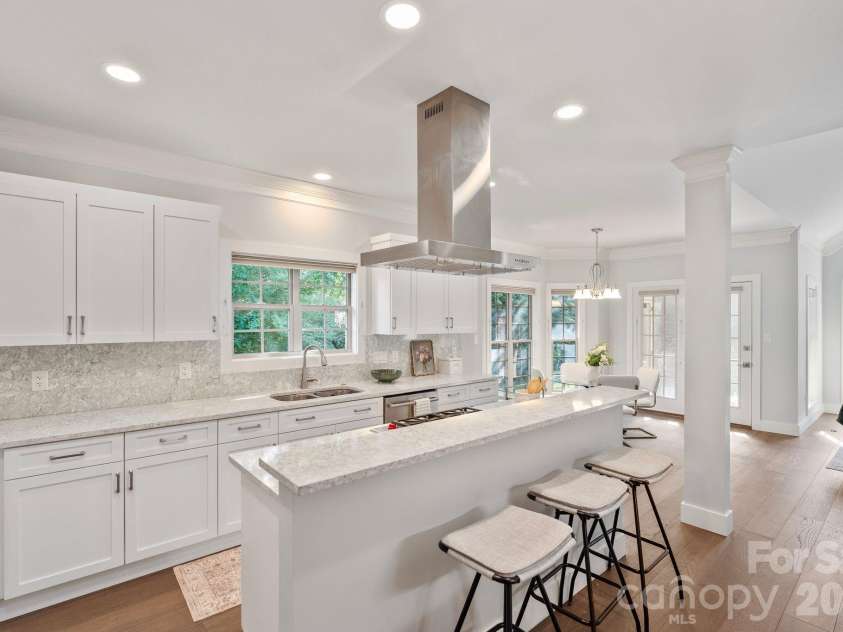 526 Ballymote Court, Matthews, NC 28104.  MLS# CAR4388258, YatesRealty ID 31207. Kitchen – Beautifully renovated and thoughtfully designed, this chef-inspired kitchen features quartz countertops, custom cabinetry, a Wolf gas cooktop with statement vent hood, Wolf wall oven, GE Monogram refrigerator,