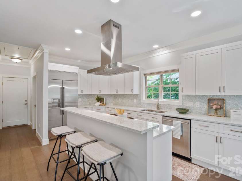 526 Ballymote Court, Matthews, NC 28104.  MLS# CAR4388258, YatesRealty ID 31207. Kitchen – Crafted for culinary enthusiasts, this exceptional kitchen features a Wolf gas cooktop, Wolf wall oven, GE Monogram refrigerator, quartz countertops, and expansive custom cabinetry designed to maximize storage
