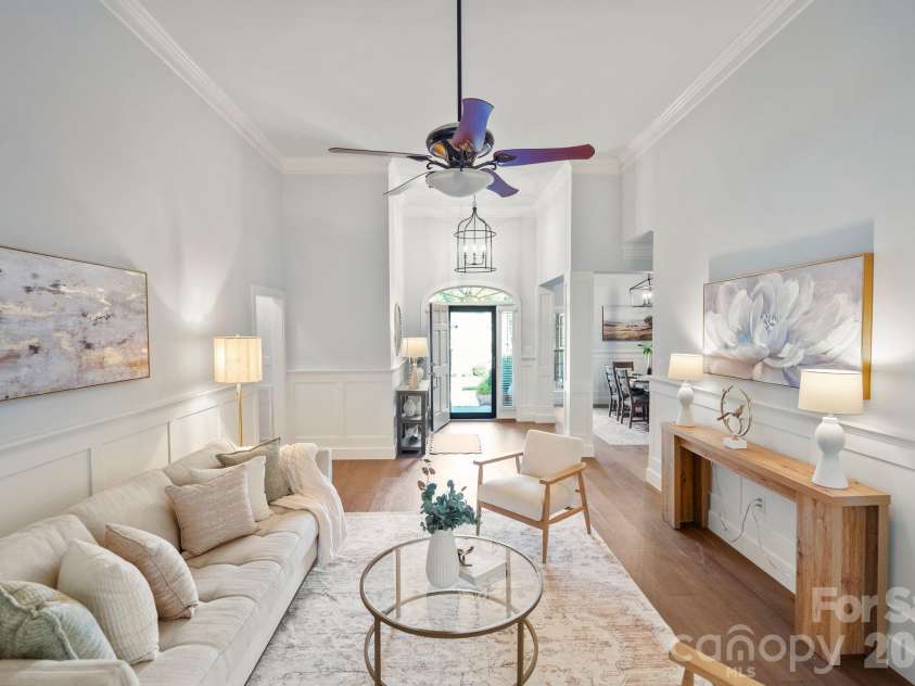 526 Ballymote Court, Matthews, NC 28104.  MLS# CAR4388258, YatesRealty ID 31207. Living Room – Impressive architectural details include high ceilings, custom trim work, and graceful sightlines extending to the adjacent sunroom. A bright, airy design enhances the home’s open-concept flow.
