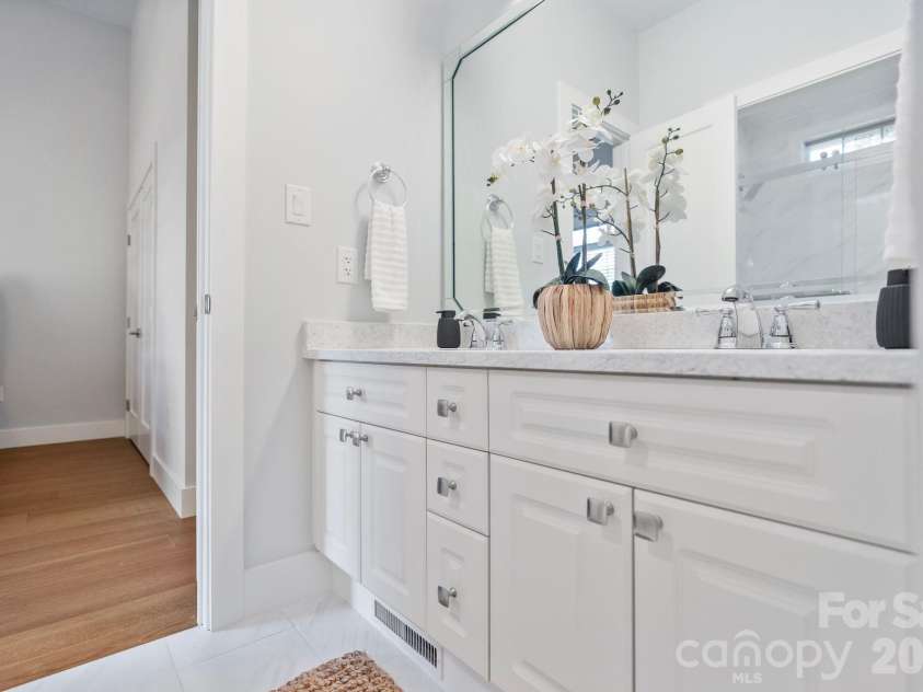 526 Ballymote Court, Matthews, NC 28104.  MLS# CAR4388258, YatesRealty ID 31207. Thoughtfully redesigned for both style and functionality, this renovated bathroom features marble-look tile, contemporary cabinetry, and a spacious walk-in shower with elegant finishes.