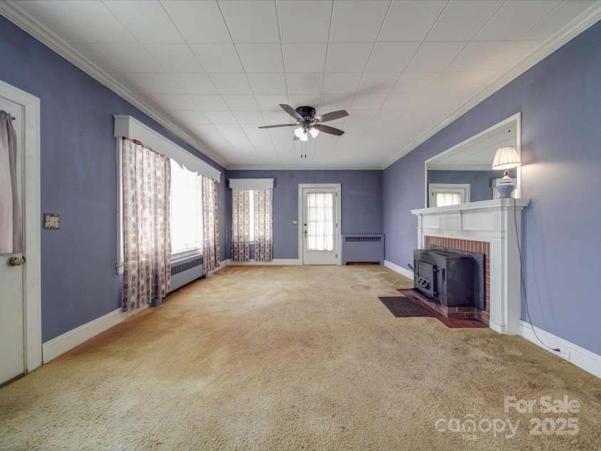 5237 NC Highway 90 E Highway, Hiddenite, NC 28636.  MLS# CAR4143514, YatesRealty ID 3126. Living room with decorative fireplace w/ wood insert