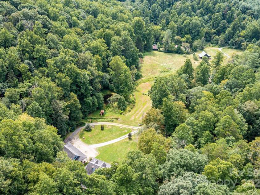 226 Wildcat Mountain Trail, Sylva, NC 28779.  MLS# CAR4284312, YatesRealty ID 31290. Aerial photo shows the vast 7+ acres of pasture from the home to the barn in distance