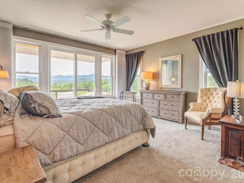 18 Adas Way, Weaverville, NC 28787.  MLS# CAR4385497, YatesRealty ID 31334. The custom electric blinds spanning the south wall of this room offer complete day and night light control, allowing you to wake gently, sleep deeply, always with a mountain view waiting