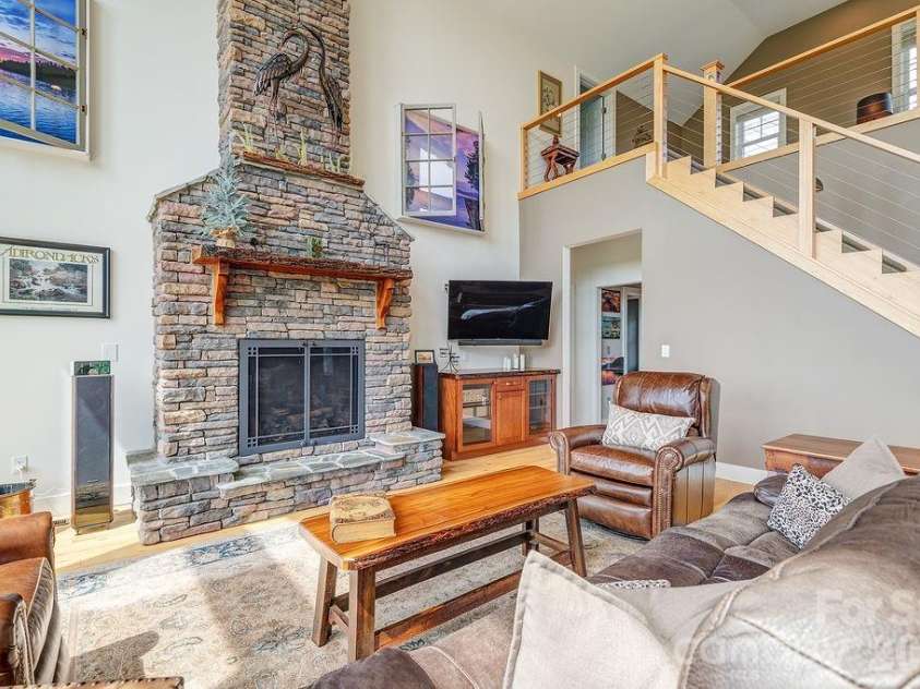 18 Adas Way, Weaverville, NC 28787.  MLS# CAR4385497, YatesRealty ID 31334. The inviting living room features handcrafted built-ins and a stunning gas fireplace finished in floor-to-ceiling slate with double mantles