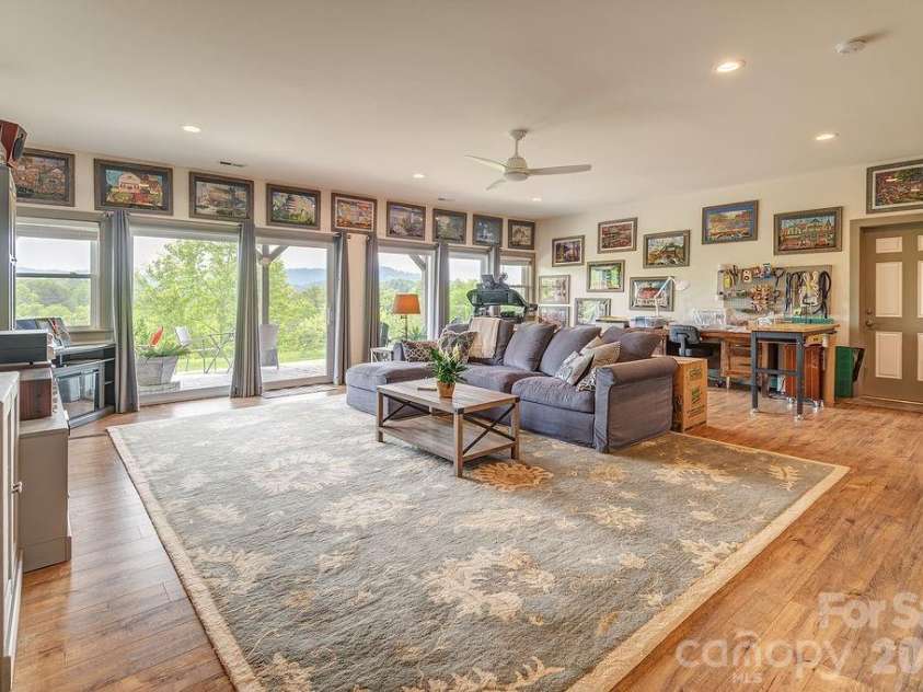 18 Adas Way, Weaverville, NC 28787.  MLS# CAR4385497, YatesRealty ID 31334. The lower level surprises at every turn, from the 9-ft ceilings, white oak LVP flooring, walk-out patio access, and mountain views that rival any floor above