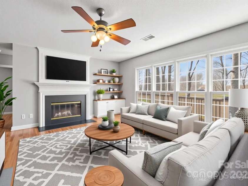8802 Glenside Street, Huntersville, NC 28078.  MLS# CAR4316716, YatesRealty ID 31376. Living room with multiple windows and a wood burning fireplace (virtually staged).