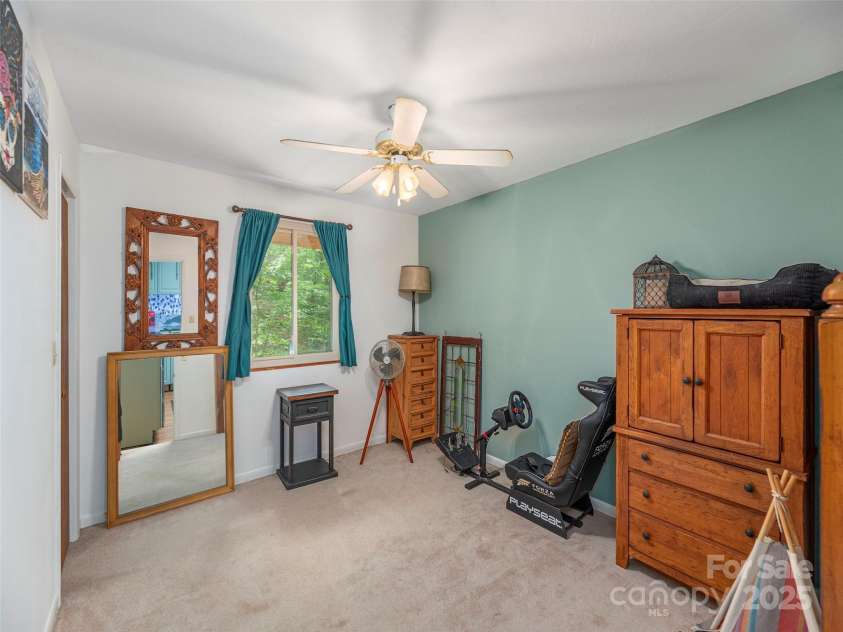 160 Tracy Place, Clyde, NC 28721.  MLS# CAR4282174, YatesRealty ID 31389. Bright bedroom with large window, neutral tones, and space for furnishings or a home office setup.