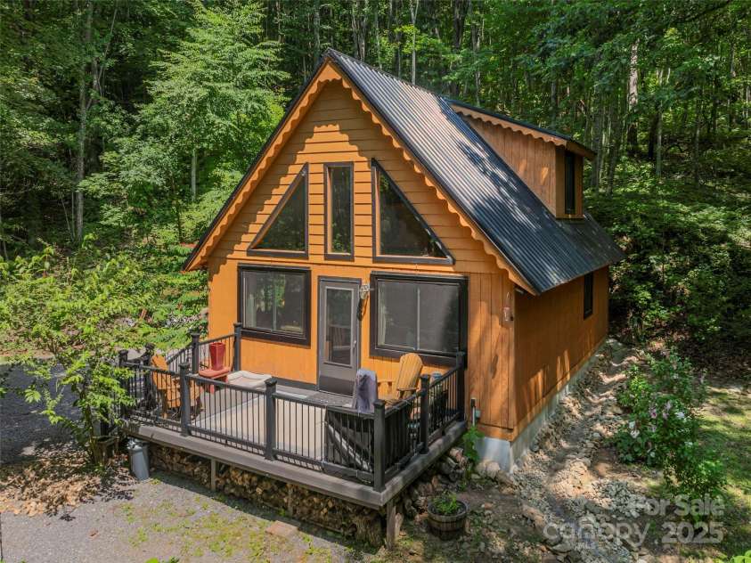 160 Tracy Place, Clyde, NC 28721.  MLS# CAR4282174, YatesRealty ID 31389. Charming A-frame cabin with striking black metal roof, expansive front deck, and a serene wooded setting for ultimate privacy.Charming A-frame cabin with striking black metal roof, expansive front deck, and a serene wooded set