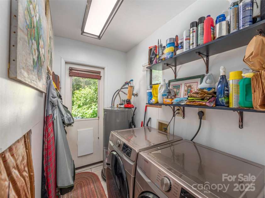 160 Tracy Place, Clyde, NC 28721.  MLS# CAR4282174, YatesRealty ID 31389. Laundry room with utility sink, shelving for storage, and exterior access.
