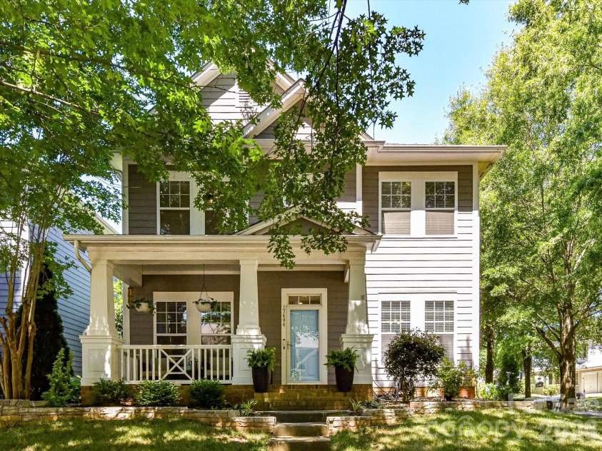 17404 Harbor Walk Drive, Cornelius, NC 28031.  MLS# CAR4393057, YatesRealty ID 31396. A charming two-story home located on a corner lot, with classic Craftsman-inspired architecture, a welcoming covered front porch, and mature shade trees creating exceptional curb appeal.
