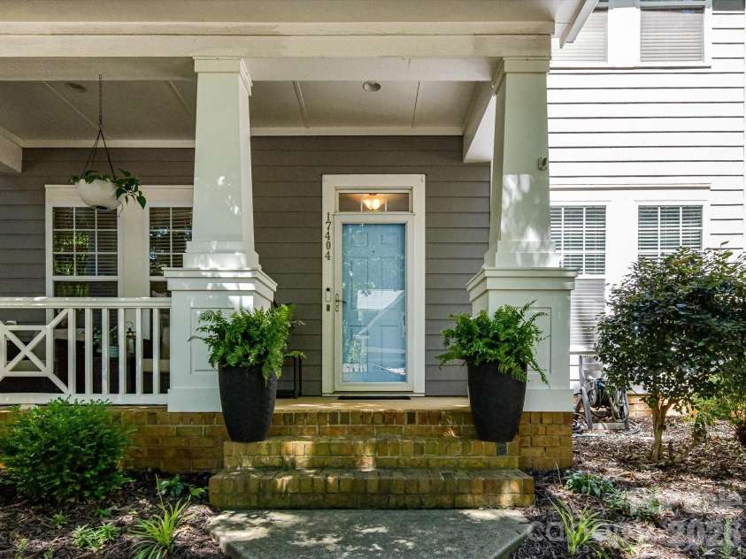 17404 Harbor Walk Drive, Cornelius, NC 28031.  MLS# CAR4393057, YatesRealty ID 31396. A welcoming covered front porch with classic columns, charming architectural details, and a cheerful entry creates a warm first impression for guests and homeowners alike.