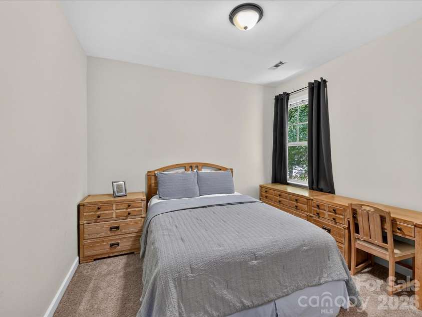 17404 Harbor Walk Drive, Cornelius, NC 28031.  MLS# CAR4393057, YatesRealty ID 31396. Bedroom 2 provides a comfortable and versatile space with soft carpeting, abundant natural light, and room for both relaxation and productivity.