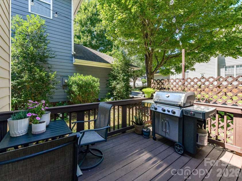 17404 Harbor Walk Drive, Cornelius, NC 28031.  MLS# CAR4393057, YatesRealty ID 31396. Step outside to a charming back deck with space for grilling, dining, and relaxing beneath string lights, all surrounded by mature greenery for added privacy.