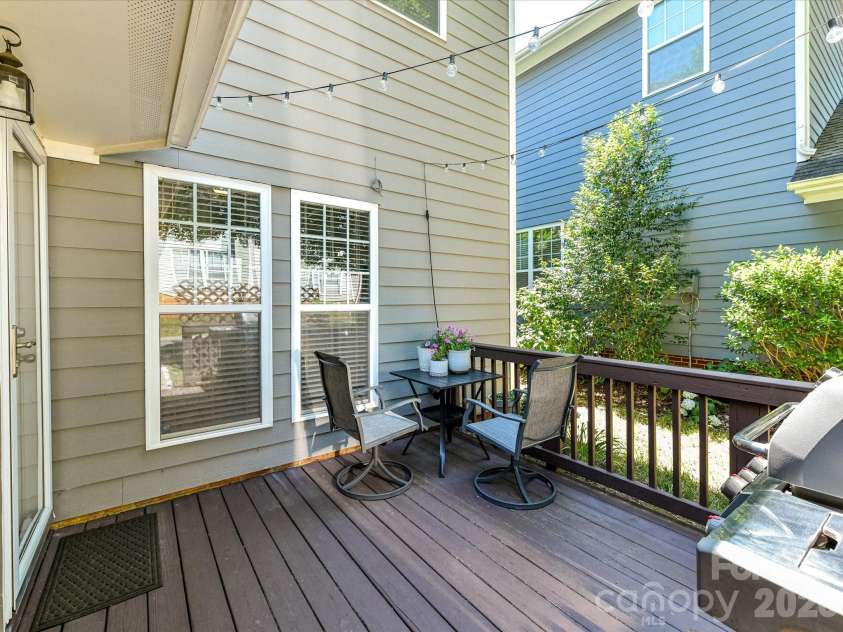 17404 Harbor Walk Drive, Cornelius, NC 28031.  MLS# CAR4393057, YatesRealty ID 31396. Step outside to a charming back deck with space for grilling, dining, and relaxing beneath string lights, all surrounded by mature greenery for added privacy.