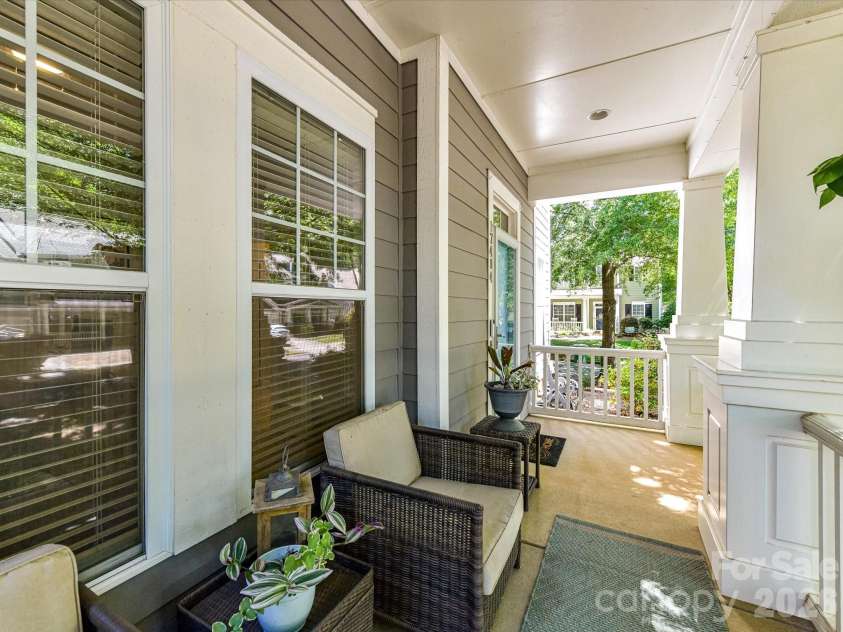 17404 Harbor Walk Drive, Cornelius, NC 28031.  MLS# CAR4393057, YatesRealty ID 31396. The inviting covered front porch offers a peaceful place to relax with comfortable seating, classic architectural details, and charming views of the tree-lined neighborhood.