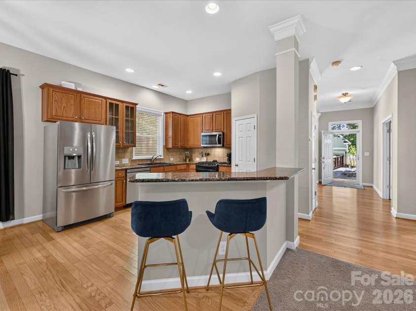 17404 Harbor Walk Drive, Cornelius, NC 28031.  MLS# CAR4393057, YatesRealty ID 31396. The spacious kitchen is designed for both everyday living and entertaining, featuring abundant cabinetry, granite countertops, stainless steel appliances, a breakfast bar, pantry, and a sunny dining area filled wit