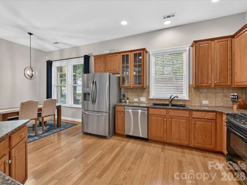 17404 Harbor Walk Drive, Cornelius, NC 28031.  MLS# CAR4393057, YatesRealty ID 31396. The spacious kitchen is designed for both everyday living and entertaining, featuring abundant cabinetry, granite countertops, stainless steel appliances, a breakfast bar, pantry, and a sunny dining area filled wit