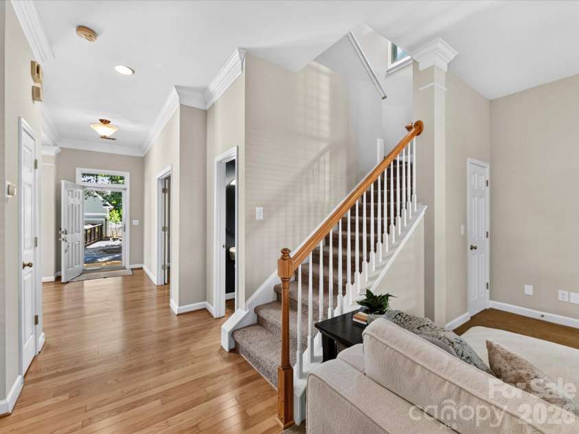 17404 Harbor Walk Drive, Cornelius, NC 28031.  MLS# CAR4393057, YatesRealty ID 31396. The staircase to the upper level creates an elegant architectural focal point, featuring classic white balusters, warm wood accents, and an open design that enhances the home's spacious feel.