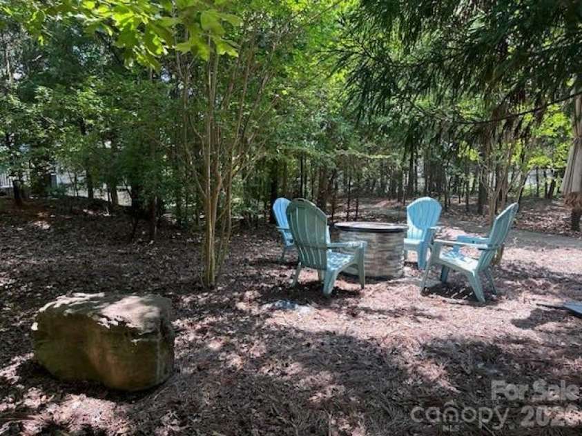 14943 Bagley Lane, Charlotte, NC 28227.  MLS# CAR4392753, YatesRealty ID 31402. Back yard with trees and fire pit