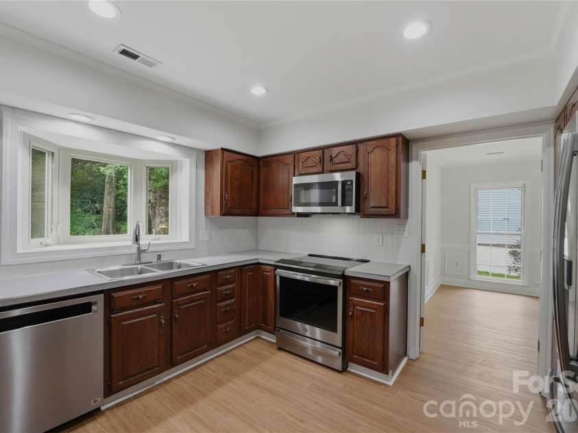 2341 Hamilton Mill Road, Charlotte, NC 28270.  MLS# CAR4391403, YatesRealty ID 31412. Kitchen has newer stainless appliances and induction cooktop range, new tiled backsplash and new lighting.